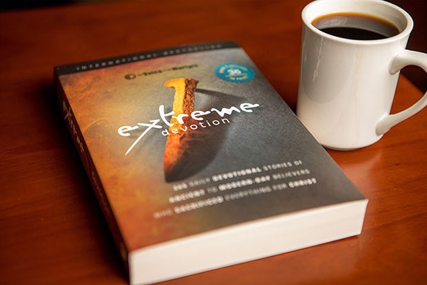 Extreme Devotion book on table alongside a cup of coffee
