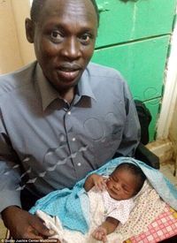 Daniel Wani met his daughter Maya for the first time in the prison where his wife is being held. (Photo Credit: MailOnline / Justice Centre Sudan) Daniel Wani and child
